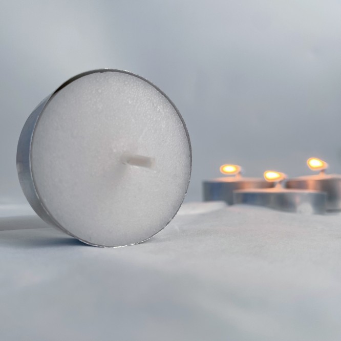 Unscented white tealight candle in aluminum cup close up